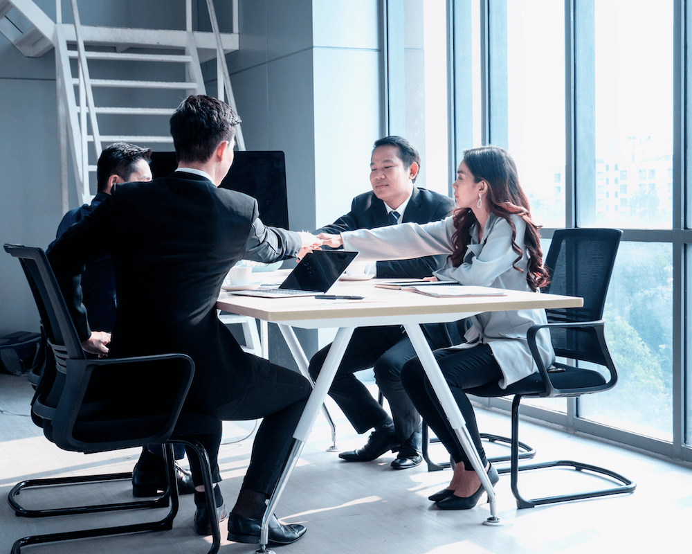 Business solicitor guiding clients through contract signing in a modern office setting