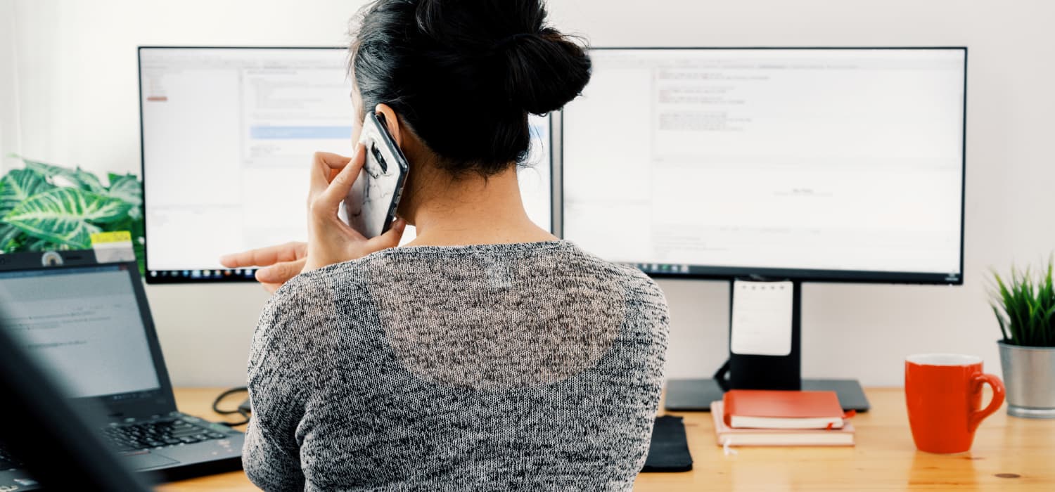 A person working on a computer in an office, symbolising the experience of managerial bullying, with subtle signs of stress and frustration visible.