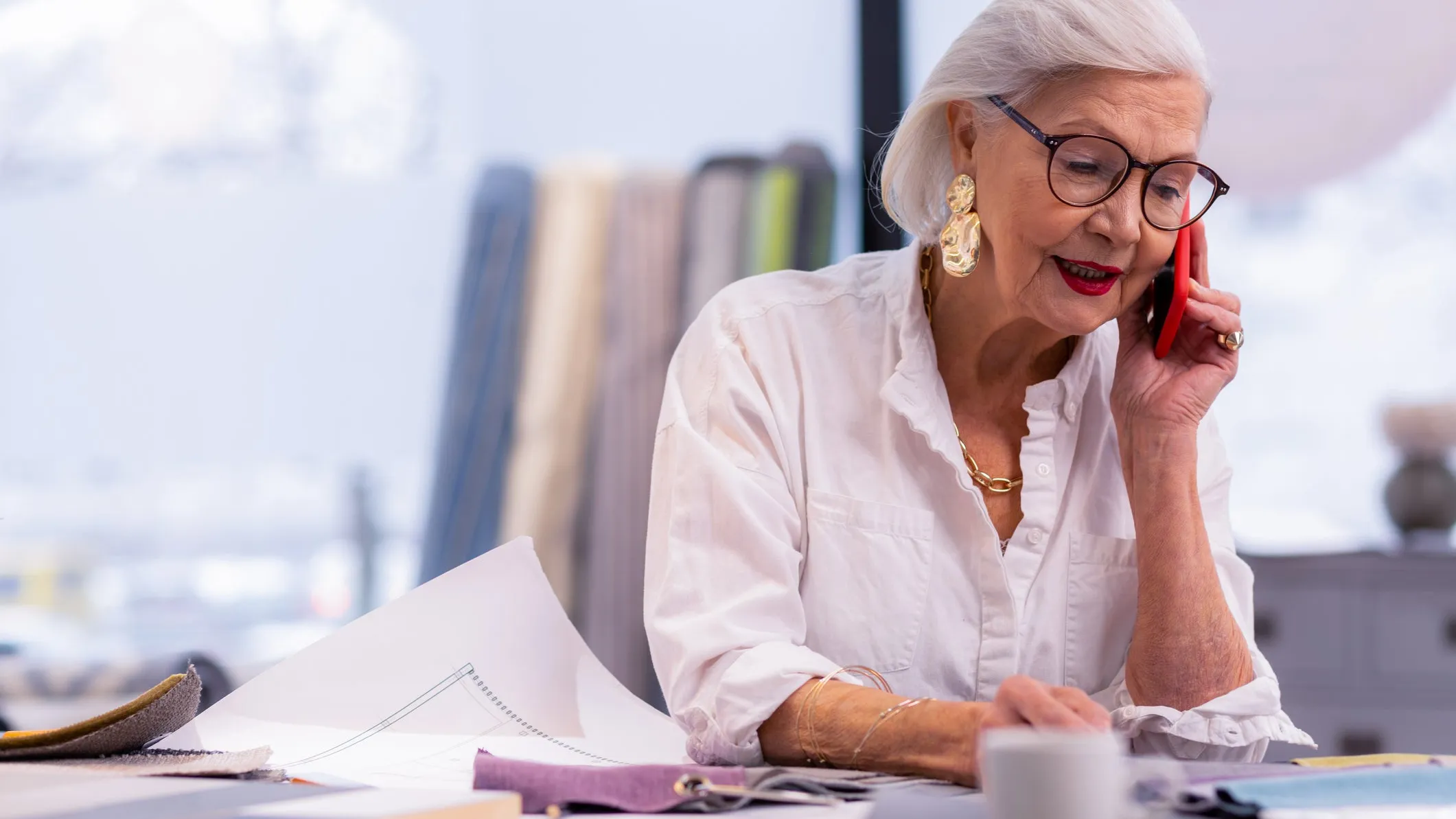 A senior woman in an office environment speaking on the phone, symbolising the process of seeking legal advice on how to prove workplace harassment, relevant for Locate Solicitors.